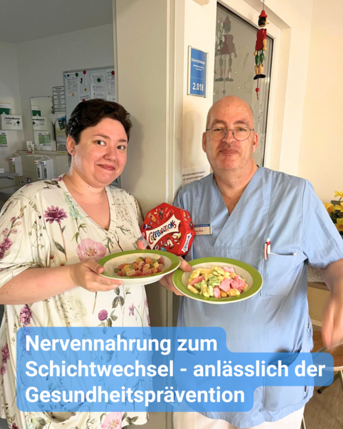 Eine Frau und ein Mann in Arbeitskleidung halten Teller mit Gummibärchen. Text: 'Nervennahrung zum Schichtwechsel - anlässlich der Gesundheitsprävention'.